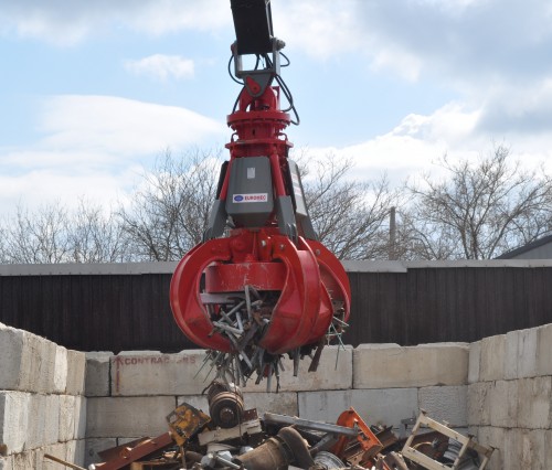 red scrap grapple with magnet moving scrap metal with magnet