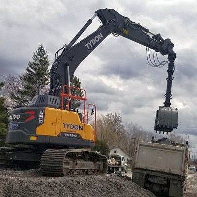 Excavator using a clamshell bucket to load a dump truck